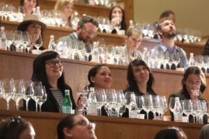 Students in our class smiling while tasting sake from wine glasses